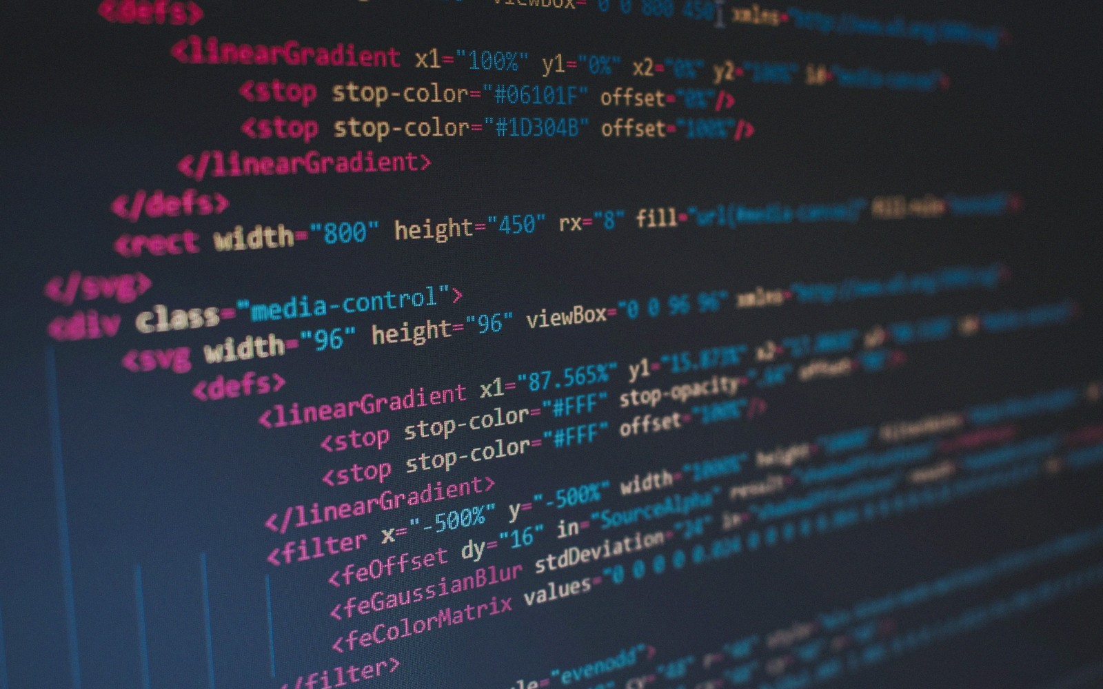 Close-up of SVG and CSS code with linear gradients and filters on a dark screen